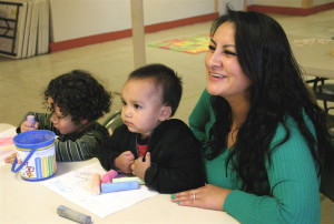 A caregivers / instructor teaches early childhood learning skills courtesy of the Arizona Kith and Kin Project.